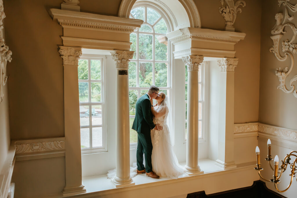 Couple Photos in the window at Crowcombe Court during a summer wedding in Somerset, captured by a Crowcombe Court wedding photographer.