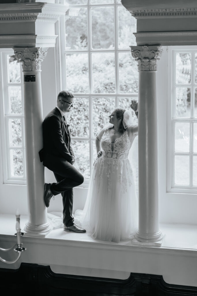 Couple Photos in the window at Crowcombe Court during a summer wedding in Somerset, captured by a Crowcombe Court wedding photographer.