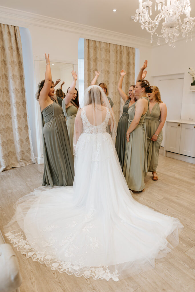 First look with bridesmaids at Crowcombe Court during a summer wedding in Somerset, captured by a Crowcombe Court wedding photographer.