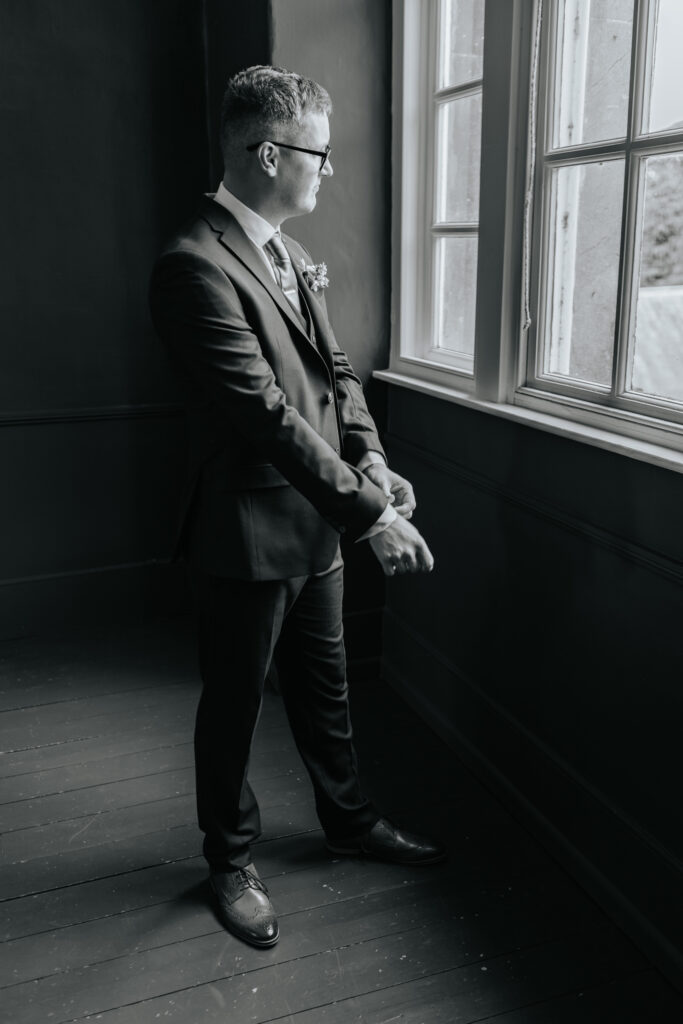 Groom getting ready in the Groom Room at Crowcombe Court during a summer wedding in Somerset, captured by a Crowcombe Court wedding photographer