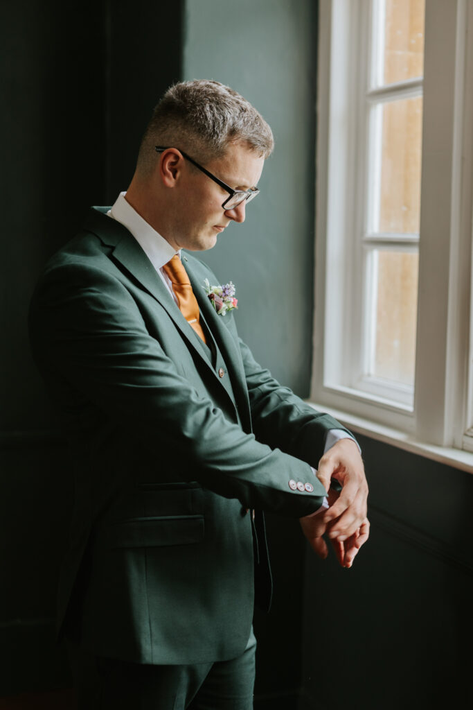 Groom getting ready in the Groom Room at Crowcombe Court during a summer wedding in Somerset, captured by a Crowcombe Court wedding photographer