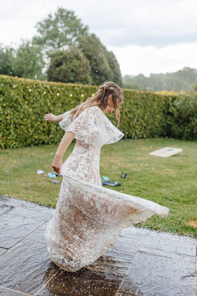 Bride Hannah dancing in the rain and hail at Priston Mill near Bath