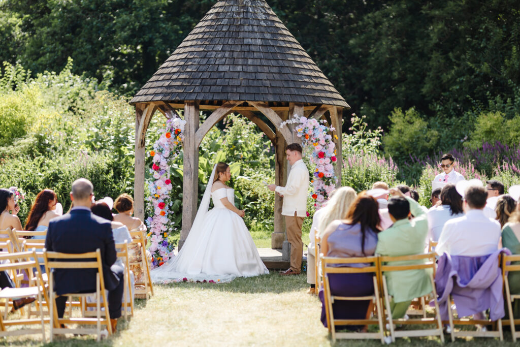 Wedding Ceremony at Priston Mill near Bath with Bridgeton style decor and flower arch